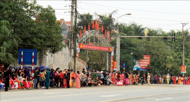 Photo: People stand along streets to see off DPRK Chairman Kim Jong-un. VNA Photo