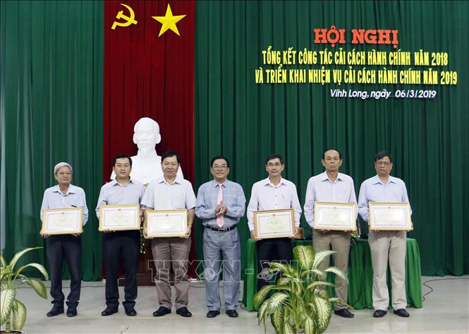 Trong ảnh: Phó Chủ tịch UBND tỉnh Vĩnh Long Trần Hoàng Tựu trao Bằng khen của UBND tỉnh Vĩnh Long cho 6 tập thể có thành tích xuất sắc trong phong trào thi đua thực hiện cải cách hành chính năm 2018. Ảnh: Phạm Minh Tuấn-TTXVN