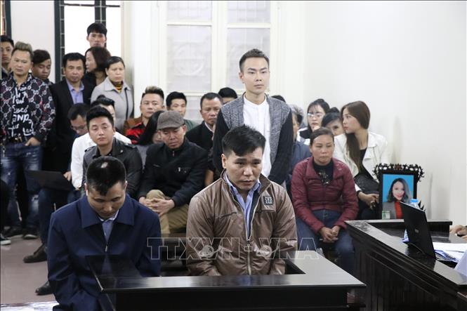 Trong ảnh: Nhân chứng Đoàn Quý Nguyên (tức ca sỹ Nam Khang, người đứng phía sau) khai báo trước Tòa. Ảnh: Kim Anh – TTXVN
