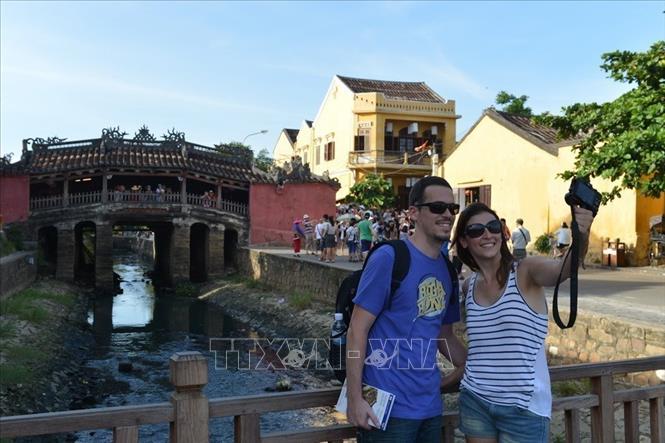 Photo: Foreign visitors at the Bridge Pagoda of Hoi An ancient town. VNA Photo: Thanh Hà