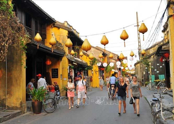 Photo: Visitors walking on a street of Hoi An. VNA Photo: Minh Đức