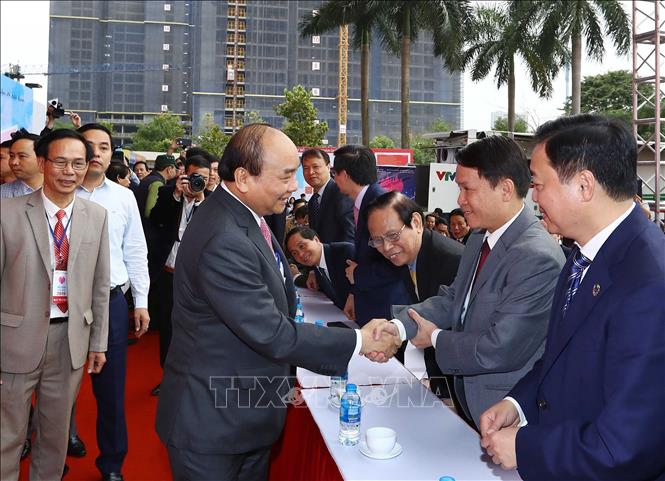 Trong ảnh: Thủ tướng Nguyễn Xuân Phúc bắt tay Tổng giám đốc TTXVN Nguyễn Đức Lợi và các đại biểu dự khai mạc. Ảnh: Thống Nhất - TTXVN