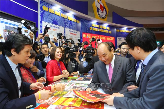 Trong ảnh: Thủ tướng Nguyễn Xuân Phúc xem các ấn phẩm tại gian trưng bày của TTXVN. Ảnh: Thành Đạt - TTXVN