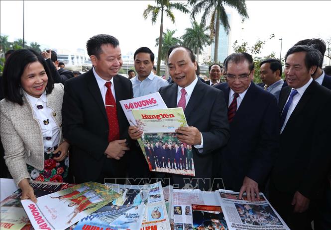  Trong ảnh: Thủ tướng Nguyễn Xuân Phúc, nguyên Tổng Bí thư Nông Đức Mạnh và các đại biểu tham quan nơi trưng bày các ấn phẩm báo chí. Ảnh: Thống Nhất - TTXVN