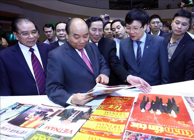 Trong ảnh: Thủ tướng Nguyễn Xuân Phúc, nguyên Tổng Bí thư Nông Đức Mạnh và các đại biểu xem các ấn phẩm tại gian trưng bày của TTXVN. Ảnh: Thống Nhất - TTXVN