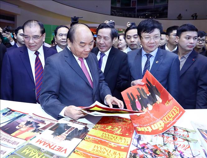 Trong ảnh: Thủ tướng Nguyễn Xuân Phúc, nguyên Tổng Bí thư Nông Đức Mạnh và các đại biểu xem các ấn phẩm tại gian trưng bày của TTXVN. Ảnh: Thống Nhất - TTXVN