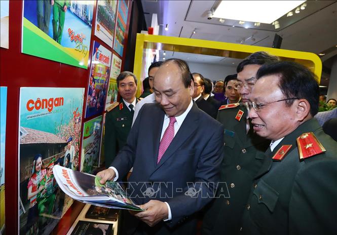 Trong ảnh: Thủ tướng Nguyễn Xuân Phúc xem các ấn phẩm của Báo Công an nhân dân. Ảnh: Thống Nhất - TTXVN