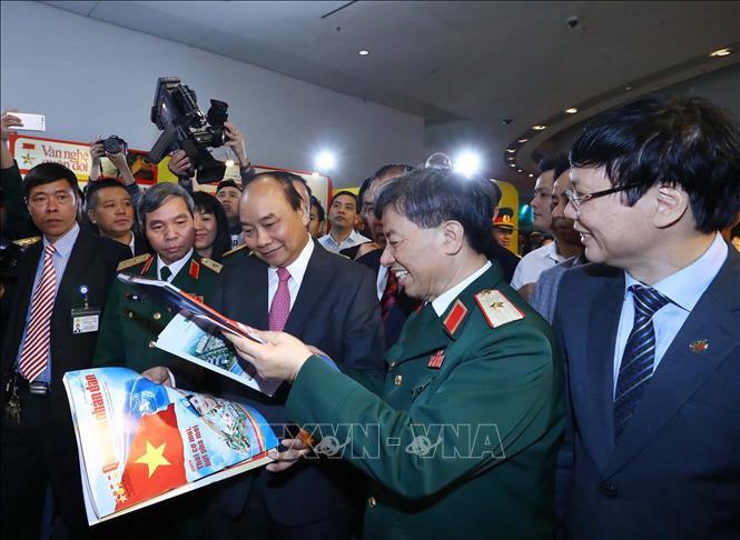 Trong ảnh: Thủ tướng Nguyễn Xuân Phúc xem các ấn phẩm của Báo Quân đội nhân dân. Ảnh: Thống Nhất - TTXVN
