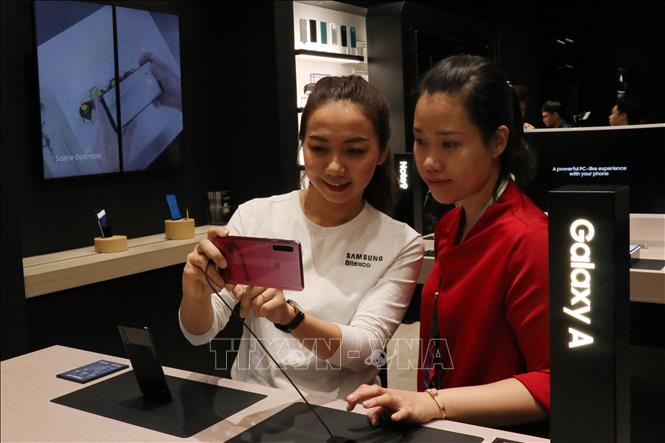 Trong ảnh: Nhân viên Samsung hướng dẫn khách tham quan trải nghiệm công nghệ tại không gian thiết bị di động. Ảnh: Tiến Lực - TTXVN