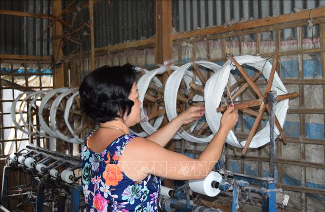 Trong ảnh: Công đoạn se chỉ của các thợ dệt tại nghề dệt choàng Long Khánh A. Ảnh: Chương Đài - TTXVN