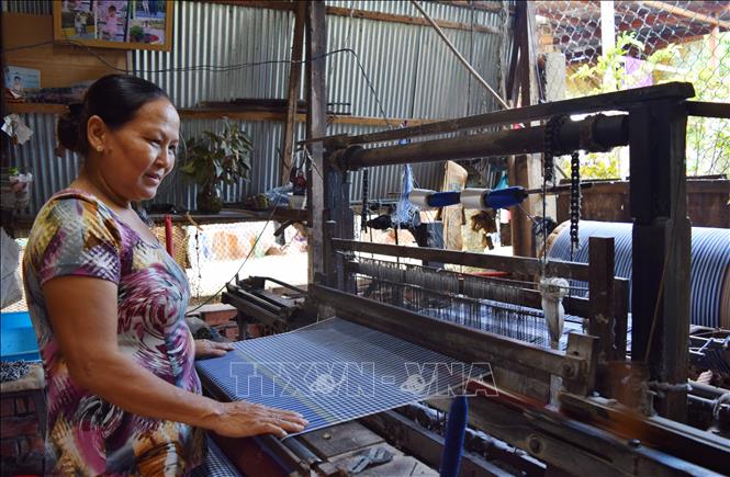 Trong ảnh: Dệt khăn choàng tại hộ sản xuất của gia đình bà Nguyễn Thị Mèn. Ảnh: Chương Đài - TTXVN