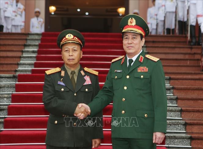 Photo: Gen. Luong Cuong (R) shakes hands with Lt. Gen. Thongloi Silivong (L). VNA Photo: Dương Giang