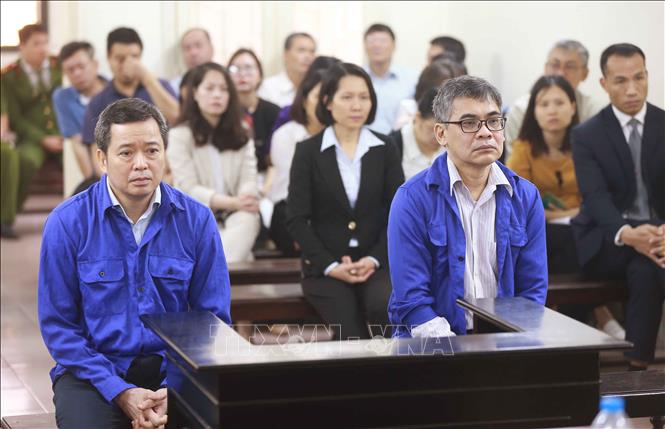 Trong ảnh: Bị cáo Võ Quang Huy (sinh năm 1961, nguyên Chánh kế toán VSP) và bị cáo Từ Thành Nghĩa (sinh năm 1962, nguyên Tổng Giám đốc VSP) và phiên tòa. Ảnh: Doãn Tấn - TTXVN
