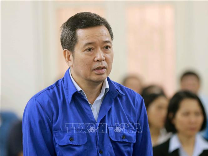 Trong ảnh: Bị cáo Võ Quang Huy (đứng bên trái, sinh năm 1961, nguyên Chánh kế toán VSP) tại phiên tòa. Ảnh: Doãn Tấn - TTXVN