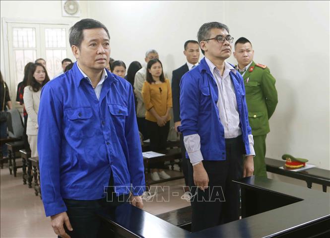 Trong ảnh: Bị cáo Võ Quang Huy (đứng bên trái, sinh năm 1961, nguyên Chánh kế toán VSP) và bị cáo Từ Thành Nghĩa (đứng bên phải, sinh năm 1962, nguyên Tổng Giám đốc VSP) tại phiên tòa. Ảnh: Doãn Tấn - TTXVN