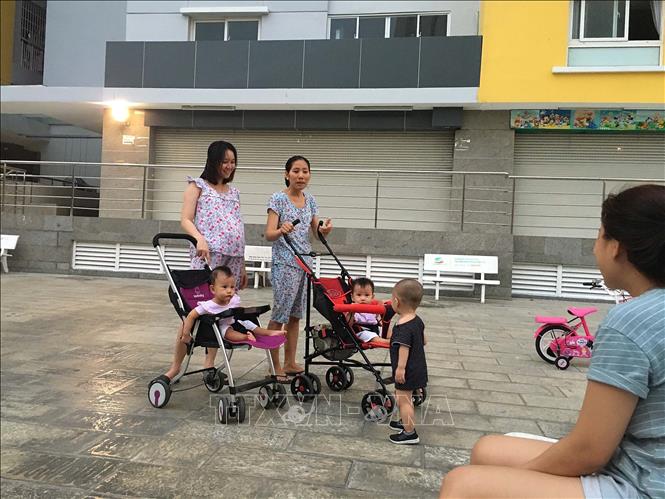 Trong ảnh: Nhiều người ở chung cư Carina đưa con trẻ xuống sảnh sân của tòa nhà chơi. Ảnh: Thanh Vũ - TTXVN