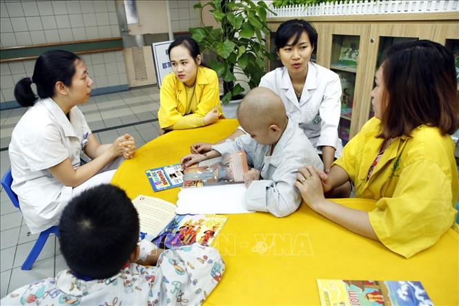 Trong ảnh: Nhân viên phòng CTXH bệnh viện Bạch Mai tham vấn, hỗ trợ chăm sóc cho bệnh nhi. Ảnh: Dương Ngọc – TTXVN