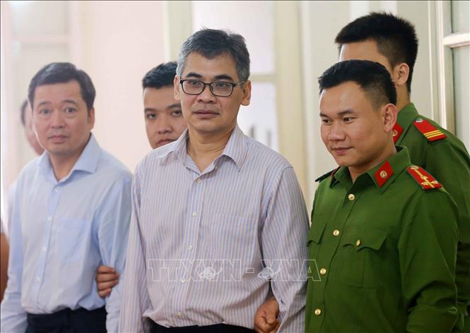 Trong ảnh: Cảnh sát dẫn giải bị cáo Võ Quang Huy (bên trái, nguyên Chánh kế toán VSP) và bị cáo Từ Thành Nghĩa (bên phải, nguyên Tổng Giám đốc VSP) rời Tòa sau khi kết thúc. Ảnh: Doãn Tấn - TTXVN