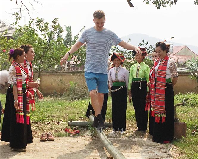 Trong ảnh: Du khách nước ngoài đi cầu kiều tại Lễ hội Hết chá. Ảnh: Nguyễn Cường - TTXVN.