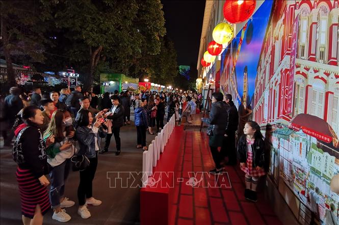 Photo: Visitors take photos with a reconstruction of Singaporean streets. VNA Photo: Thành Đạt
