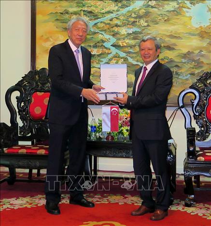 Photo: Secretary of Thua Thien - Hue Party Commitee Truong Luu (R) receives a gift from Deputy Prime Minister of Singapore Teo Chee Hean (L). VNA Photo: Tường Vi