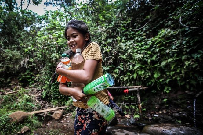 Trong ảnh: Mùa khô năm nay, việc lấy được nhiều chai nước uống tại các con nước đang dần khan hiếm trở thành niềm vui của những đứa trẻ nơi đây, giống như bé gái ở xã Eatul, huyện Cư M’gar này. Ảnh: Trọng Đạt - TTXVN