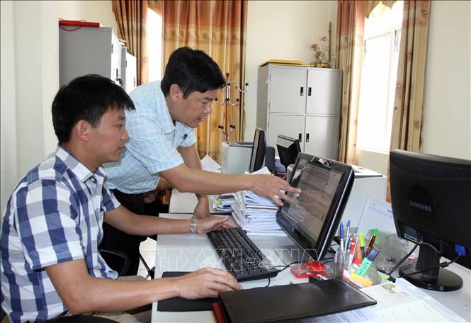 Trong ảnh: Phó Bí thư Chi bộ, Chánh Văn phòng HĐND - UBND huyện Tân Uyên hướng dẫn giúp đỡ nhân viên văn phòng xử lý công việc. Ảnh: Quý Trung – TTXVN
