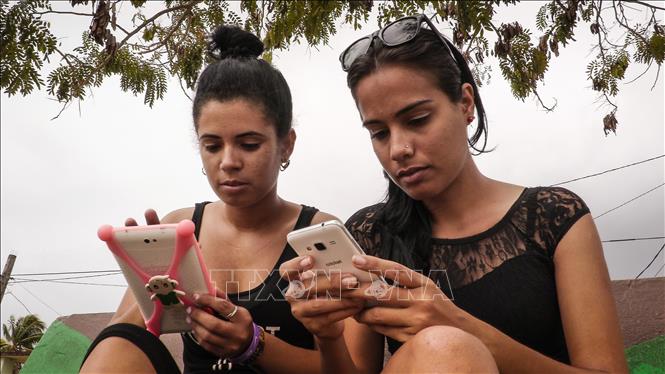 Trong ảnh: Người dân truy cập Internet trên điện thoại di động tại thị trấn Gaspar, tỉnh Ciego de Avila, Cuba. Ảnh: AFP/ TTXVN