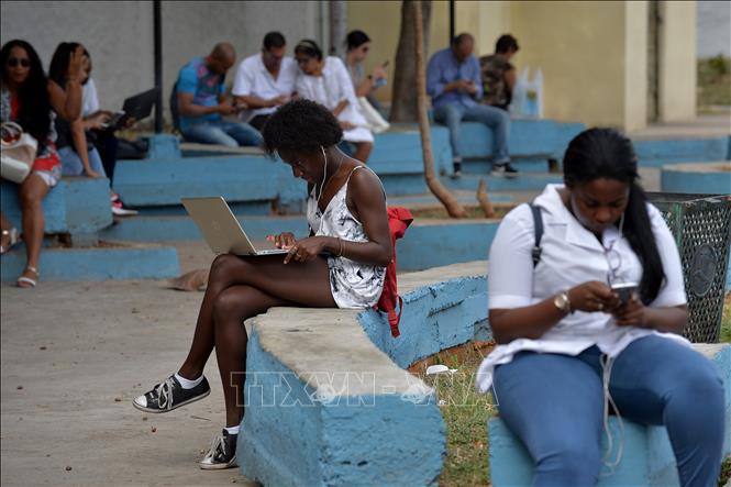 Trong ảnh: Người dân truy cập Internet trên điện thoại di động tại công viên ở thủ đô La Habana, Cuba. Ảnh: AFP/ TTXVN
