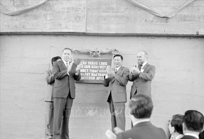 Trong ảnh: Ủy viên dự khuyết Bộ Chính trị, Phó Chủ tịch Hội đồng Bộ trưởng, Bộ trưởng Bộ Giao thông vận tải Đồng Sĩ Nguyên (thứ hai từ phải sang) cùng các chuyên gia Liên Xô thực hiện nghi thức kéo băng thông xe kỹ thuật tầng dưới cầu Thăng Long - biểu tượng của tình hữu nghị Việt - Xô, sáng 31/10/1983. Ảnh: Kim Hùng - TTXVN
