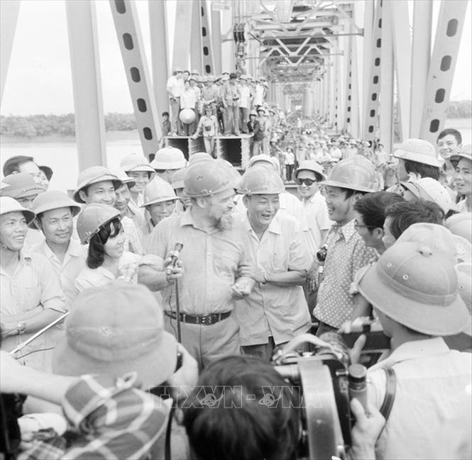 Trong ảnh: 11 giờ ngày 18/10/1983, cầu Thăng Long bắc qua sông Hồng - cây cầu của tình hữu nghị Việt - Xô chính thức nối liền 15 nhịp dầm thép dài 1680m, sau 3700 ngày lao động khẩn trương của công nhân Việt Nam và chuyên gia Liên Xô. Bộ trưởng Bộ Giao thông vận tải Đồng Sĩ Nguyên (người đứng giữa, nắm tay chuyên gia Liên Xô) đến dự và trực tiếp lắp 2 chiếc bu loong của khoang cầu cuối cùng. Ảnh: Trần Sơn - TTXVN
