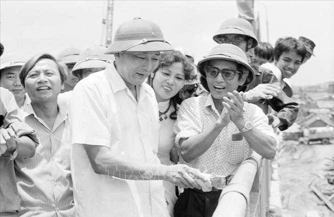 Trong ảnh: Ngày 20/6/1985, Phó Chủ tịch Hội đồng Bộ trưởng, kiêm Bộ trưởng Bộ Giao thông vận tải Đồng Sĩ Nguyên đến kiểm tra công trình xây dựng cầu Chương Dương và trực tiếp quét sơn lan can cuối cùng trước lễ thông cầu, 30/6/1985. Ảnh: Cao Phong - TTXVN

