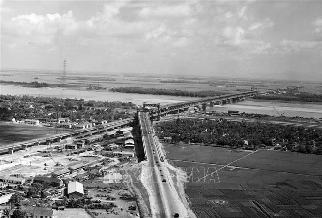 Trong ảnh: Dưới sự chỉ đạo sát sao của đồng chí Đồng Sĩ Nguyên với tư cách Bộ trưởng Bộ Giao thông vận tải, các kỹ sư, công nhân Việt Nam và chuyên gia Liên Xô đã hoàn thành xây dựng cầu Thăng Long bắc qua sông Hồng năm 1985, để cùng với cầu Chương Dương giảm tải áp lực giao thông cửa ngõ phía Bắc của Thủ đô Hà Nội. Ảnh: Cao Phong - TTXVN