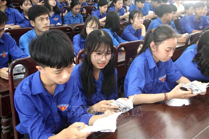 Trong ảnh: Đoàn viên thanh niên say mê đọc sách được tặng tại chương trình. Ảnh: Trịnh Bang Nhiệm - TTXVN