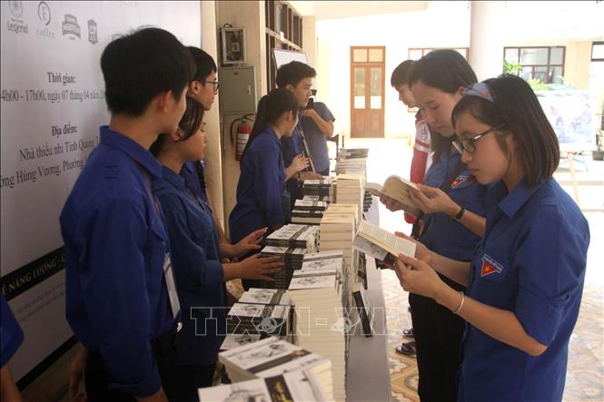 Trong ảnh: Các đoàn viên thanh niên say mê đọc sách được tặng tại chương trình. Ảnh: Trịnh Bang Nhiệm - TTXVN