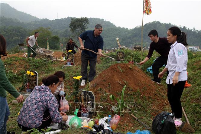Trong ảnh: Các gia đình dọn dẹp, thắp hương phần mộ tại nghĩa trang thành phố Bắc Kạn. Ảnh: Bùi Hiếu - TTXVN

