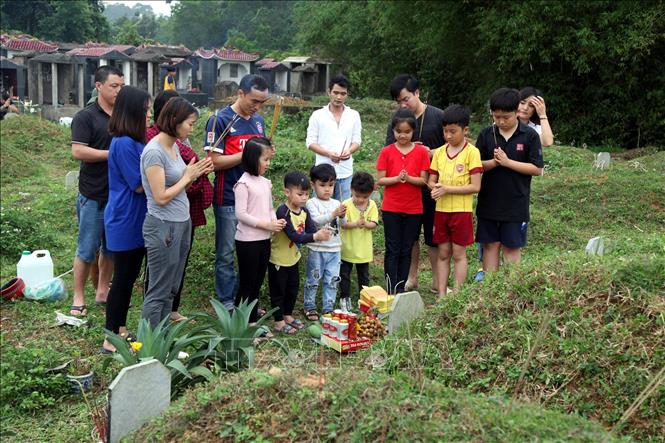 Trong ảnh: Con cháu cùng thắp hương cho phần mộ tổ tiên tại nghĩa trang thành phố Bắc Kạn. Ảnh: Bùi Hiếu - TTXVN


