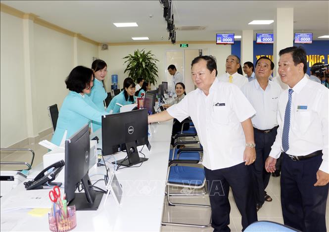Trong ảnh: Chủ tịch UBND tỉnh Vĩnh Long Nguyễn Văn Quang chúc mừng và động viên công chức, viên chức, người lao động làm việc tại Trung tâm Phục vụ hành chính công. Ảnh: Phạm Minh Tuấn-TTXVN