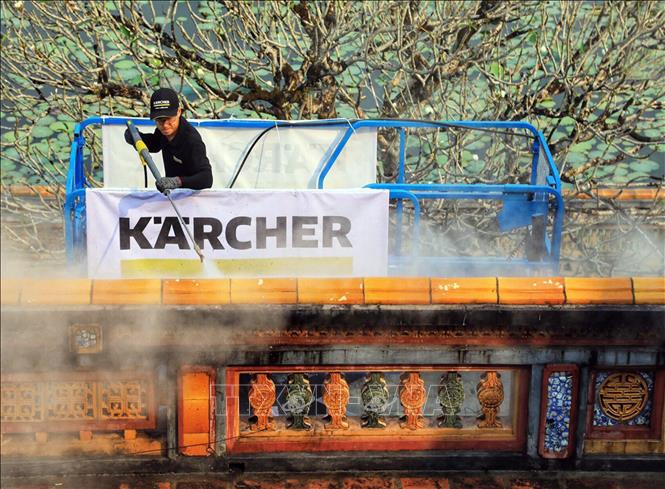 Photo: A foreign expert cleans the wall of the Ngo Mon by steam. VNA Photo: Quốc Việt 