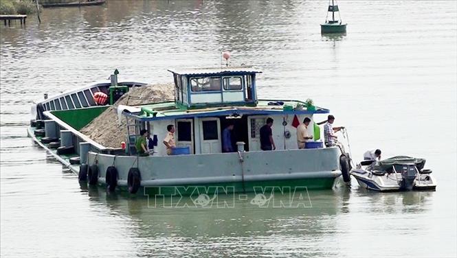 Trong ảnh: Lực lượng chức năng kiểm tra sà lan chở cát để điều tra nguyên nhân vụ tai nạn. Ảnh: Công Mạo-TTXVN