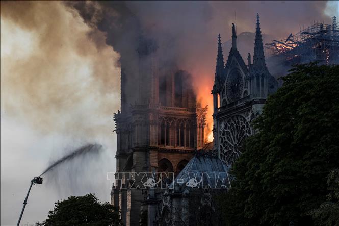 Trong ảnh: Lửa khói bốc lên dữ dội trên nóc nhà thờ Đức Bà ở Paris, Pháp ngày 15/4/2019. Ảnh: AFP/TTXVN
