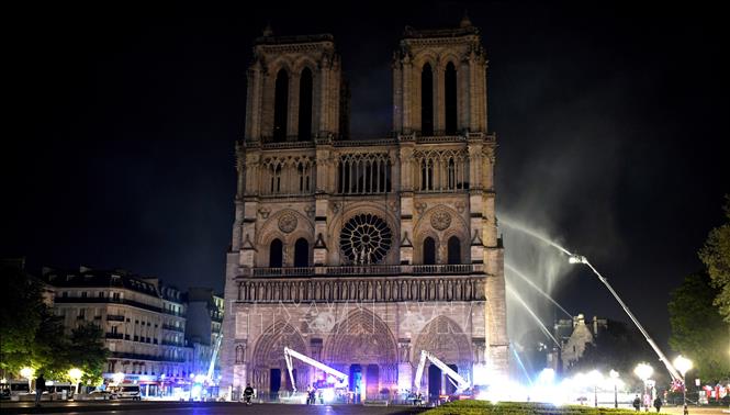 Trong ảnh: Lính cứu hỏa nỗ lực dập lửa tại hiện trường vụ cháy Nhà thờ Đức Bà ở Paris, Pháp ngày 15/4/2019. Ảnh: AFP/TTXVN
