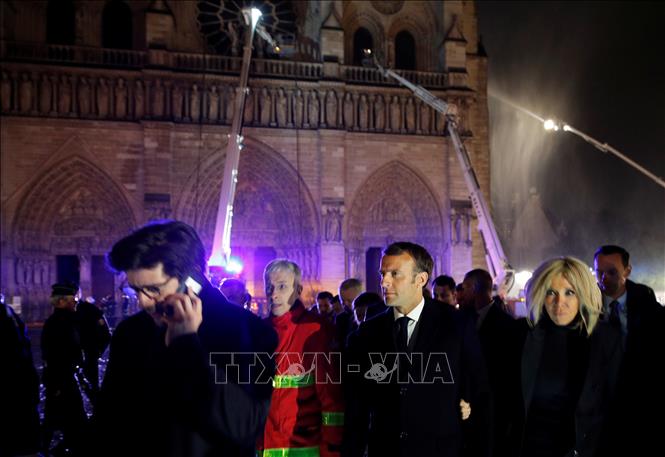 Trong ảnh: Tổng thống Pháp Emmanuel Macron (thứ 3, trái) cùng phu nhân (phải) thị sát hiện trường vụ cháy Nhà thờ Đức Bà ở Paris tối 15/4/2019. Ảnh: AFP/TTXVN