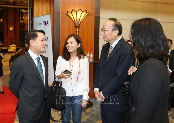 Trong ảnh: Tổng giám đốc TTXVN Nguyễn Đức Lợi trao đổi với ông Tôn Dũng, Giám đốc khu vực châu Á - Thái Bình Dương của Tân Hoa xã (Trung Quốc) tham dự hội nghị. Ảnh: TTXVN
