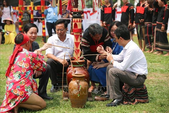 Photo: Tourists taste Ruou can (wine drunk through a pipe). VNA Photo: Trọng Đạt