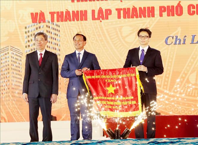 Trong ảnh: Phó Thủ tướng Vũ Đức Đam trao Cờ Thi đua của Chính phủ cho thành phố Chí Linh. Ảnh: Trọng Đức – TTXVN