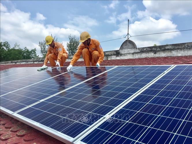 Trong ảnh: Công nhân điện lực huyện Hòa Thành (Tây Ninh) kiểm tra chất lượng các tấm pin năng lượng mặt trời lắp đặt tại nhà dân. Ảnh: Thanh Tân-TTXVN