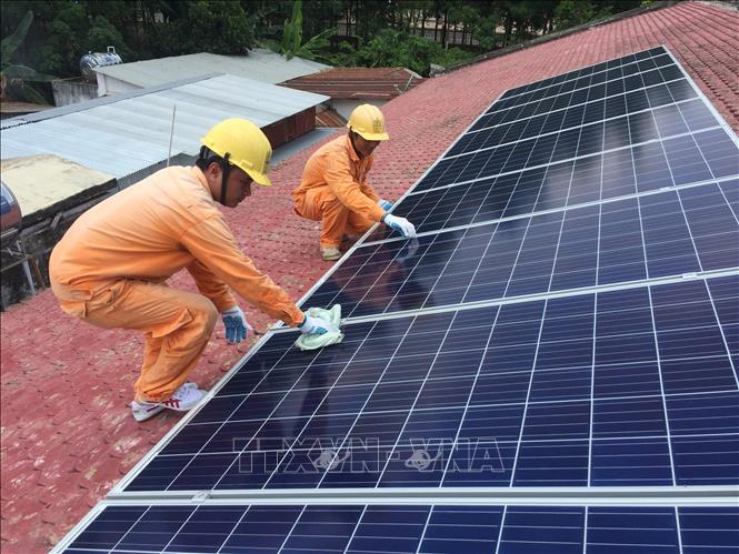 Trong ảnh: Công nhân điện lực huyện Hòa Thành (Tây Ninh) kiểm tra chất lượng các tấm pin năng lượng mặt trời lắp đặt tại nhà dân. Ảnh: Thanh Tân-TTXVN