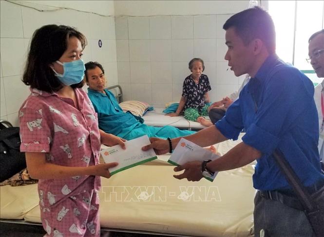 Trong ảnh: Đại diện đoàn trường Đại học Đông Á Đà Nẵng đến thăm, trao tiền quyên góp được để Cẩm Viên chữa bệnh. Ảnh: TTXVN phát