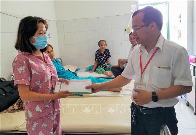 Trong ảnh: Đại diện thầy, cô giáo trường Đại học Đông Á Đà Nẵng đến thăm, trao tiền quyên góp được để Cẩm Viên chữa bệnh. Ảnh: TTXVN phát